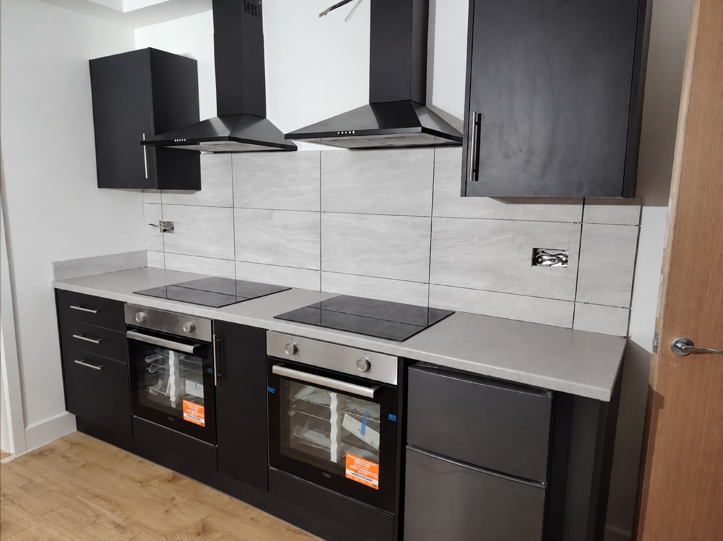 Stem’s completed kitchen with twin ovens and dark cabinets